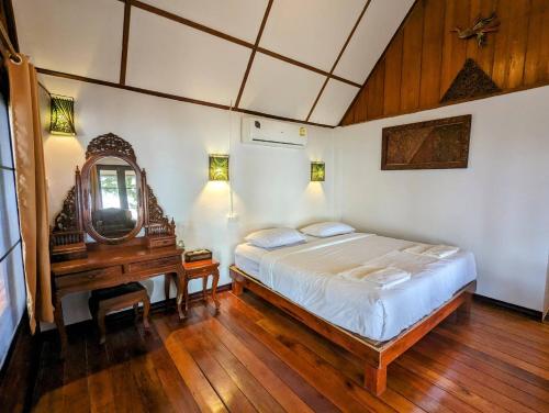 a bedroom with a bed and a mirror and a desk at Ziggy Stardust in Ko Phayam