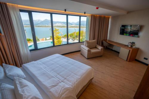 a hotel room with a bed and a large window at Duomo Resort in Shkodër