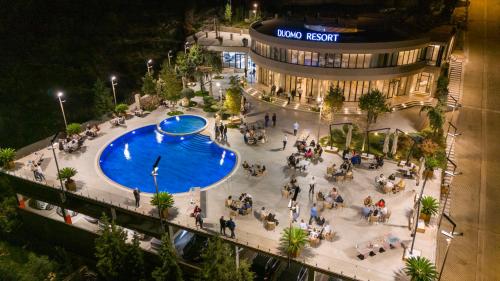 un grupo de personas de pie alrededor de una piscina en un edificio en Duomo Resort en Shkodër