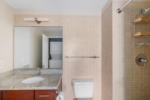 a bathroom with a toilet and a sink and a mirror at Foggy Bottom 1br w wd pool gym nr Georgetown WDC-658 in Washington, D.C.