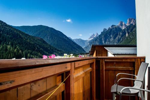 a room with a balcony with a view of mountains at Albergo Serena in Auronzo di Cadore