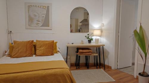 1 dormitorio con cama, mesa y espejo en Park Güell estudio, en Barcelona