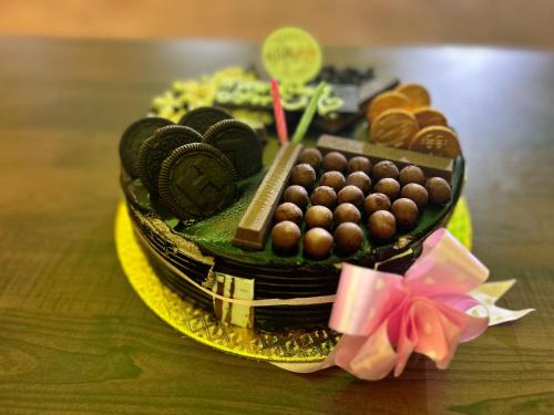 una tarta de chocolate con caramelos y galletas en una mesa en Selvas Eden Resort with river view near boat house, en Pondicherry