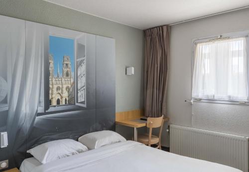 ein Hotelzimmer mit einem Bett und einem Fenster in der Unterkunft B&B HOTEL Orléans in La Chapelle-Saint-Mesmin