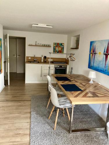 a kitchen and dining room with a wooden table and chairs at Ferienwohnung Green Village in Menden