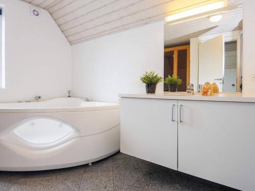 een witte badkamer met een bad en een wastafel bij 10 person holiday home in Ulfborg in Ulfborg