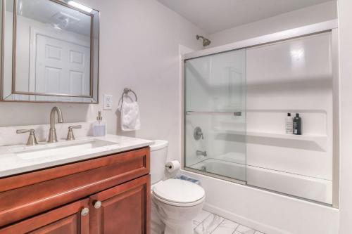 a bathroom with a shower and a toilet and a sink at Gorgeous Duplex with parking by JSQ in Jersey City
