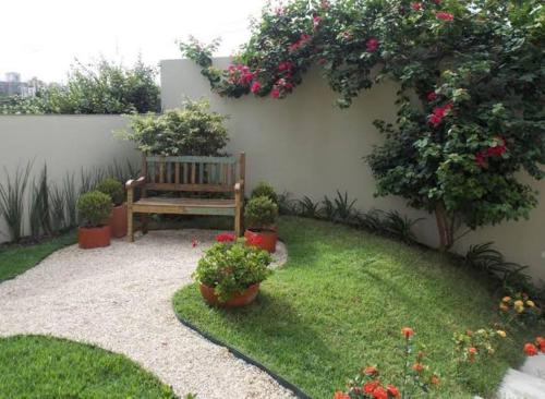 una panchina in un giardino con fiori e piante di Casinha do barco a Capão Redondo