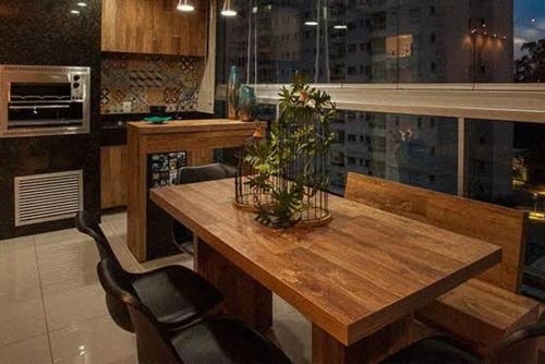 una cucina con tavolo in legno, alcune sedie, un tavolo e sidro sidx. di Casinha do barco a Capão Redondo