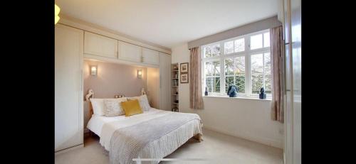 a white bedroom with a bed and a window at Meadowcroft in Lindale