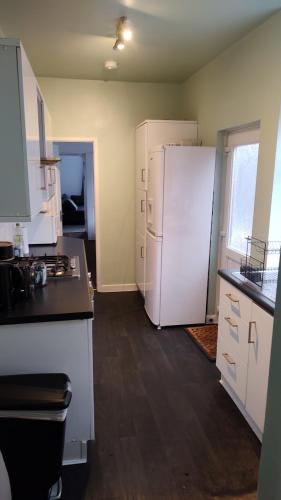 a kitchen with a white refrigerator in a room at Leicester Street in Burton upon Trent
