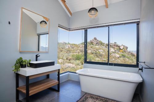 a bathroom with a tub and a sink and a window at Wolfkop Nature Reserve in Citrusdal