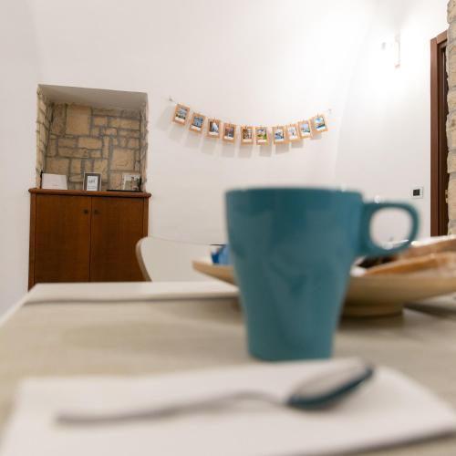 a blue coffee cup sitting on a table with a spoon at Borgo Giardino in Adelfia