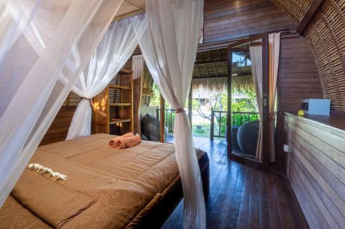 a bedroom with a bed with a canopy at brothers bungalows in Jimbaran