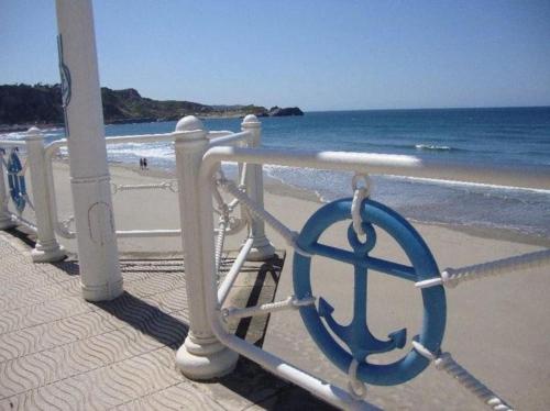 a metal railing on a beach with the ocean at Piso de Lujo en Salinas in Salinas