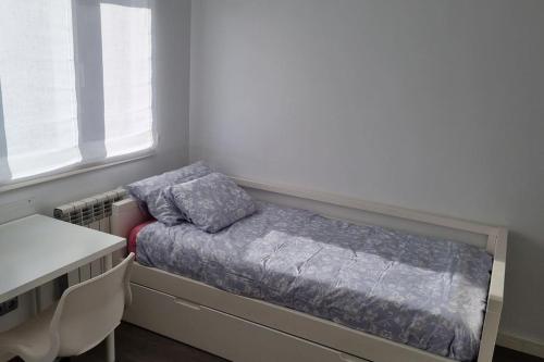 a bedroom with a bed and a desk and a window at Piso de Lujo en Salinas in Salinas