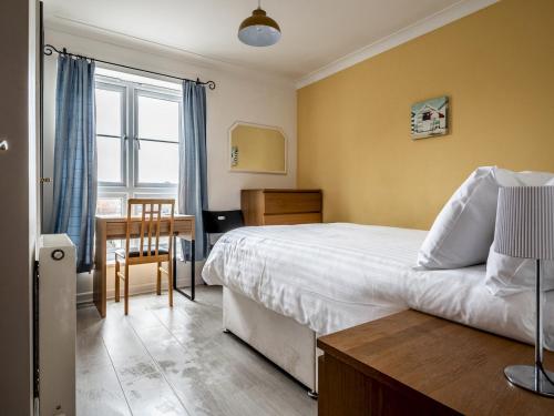 a bedroom with a bed and a desk and a chair at Pass the Keys Central townhouse with parking and modern finish in Exeter