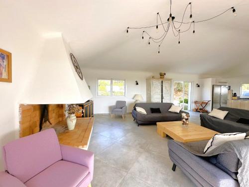 sala de estar con muebles de color púrpura y lámpara de araña en Villa Dolce, en Sainte-Lucie de Porto-Vecchio