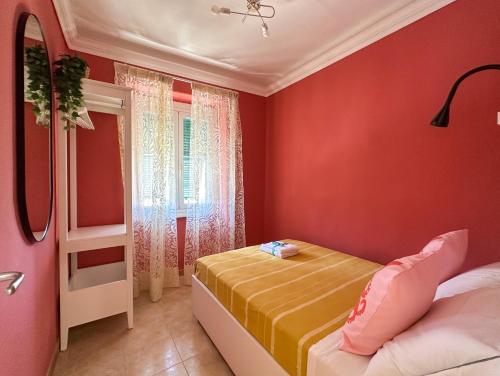 a red bedroom with a bed and a window at Ca' Bea with AC and Terrace in Vernazza