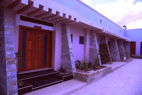 a house with a wooden door and stairs on it at MICASA Hotel in Mbarara