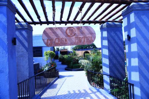 a sign for a wood shop is hanging over a walkway at MICASA Hotel in Mbarara