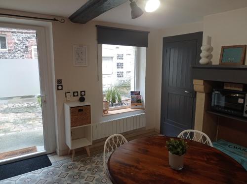 a dining room with a table and chairs and a window at Gîte Quai N 10 in Saint-Valéry-en-Caux