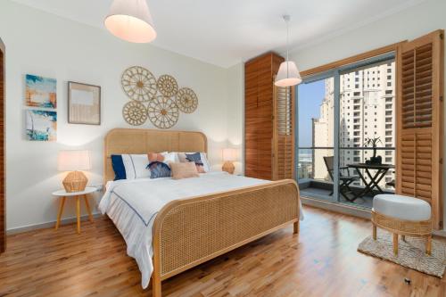 a bedroom with a bed and a large window at Boutique Apartment Sea Views - Dubai Marina in Dubai