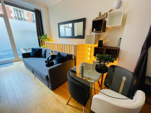 un salon avec un canapé et une table dans l'établissement Le refuge du 15, à Paris