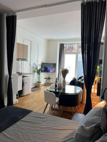 une chambre avec un lit et une salle à manger avec une table dans l'établissement Le refuge du 15, à Paris