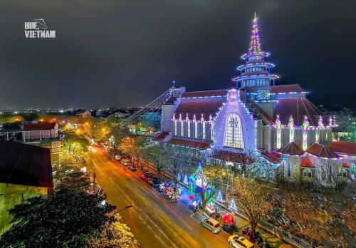 a large building with a lit up tower at night at Nana Homestay & Villa in Hue