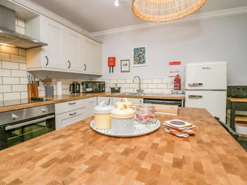 a kitchen with a wooden table with two coffee cups on it at Meadow Rue in Windermere