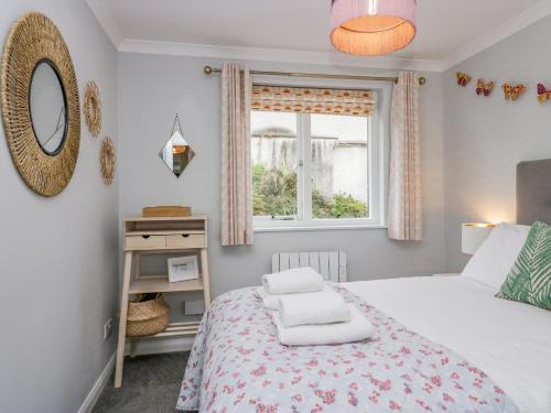 a bedroom with a bed and a window at Meadow Rue in Windermere