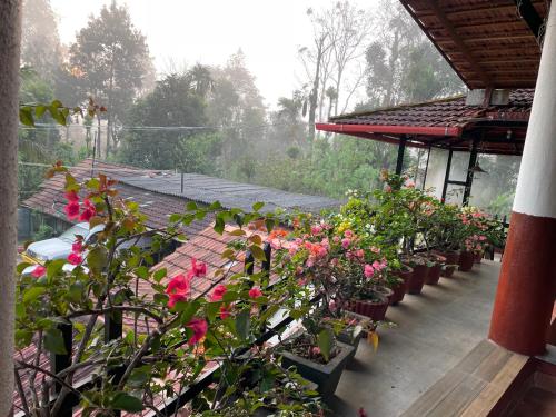 a bunch of flowers in pots on a porch at Coorg Northbreeze Estate stay in Madikeri