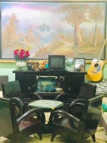 a living room with a desk with a computer and chairs at Nana Homestay & Villa in Hue