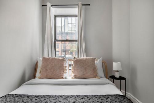 Schlafzimmer mit einem weißen Bett und einem Fenster in der Unterkunft East Village 2br w wd nr union square NYC-1260 in New York