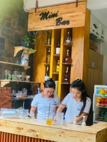 two women sitting at a counter in a coffee shop at Nana Homestay & Villa in Hue