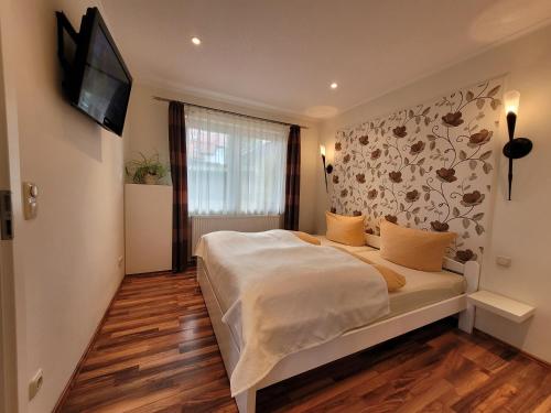 ein Schlafzimmer mit einem Bett und einem TV an der Wand in der Unterkunft Ferienwohnungen "Yvonne Zacher-Schult" in Kühlungsborn