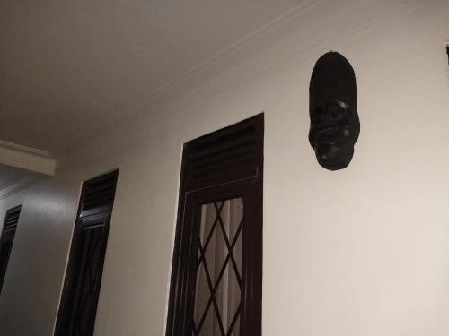 a mask hanging on a wall next to a door at Travel Sanctuary residence - Luxury2 in Kampala