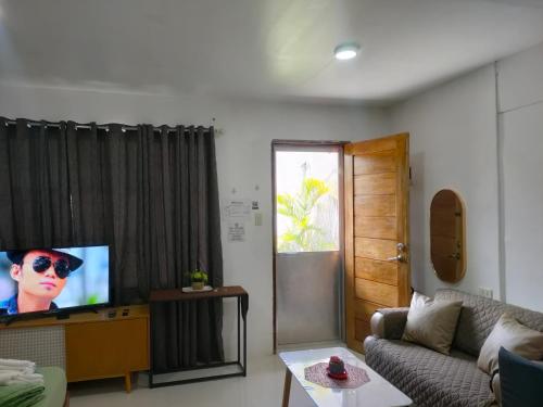 a living room with a couch and a television at Gensan Homey Apartment in General Santos