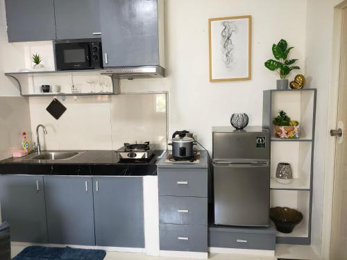 a kitchen with a sink and a refrigerator at Gensan Homey Apartment in General Santos