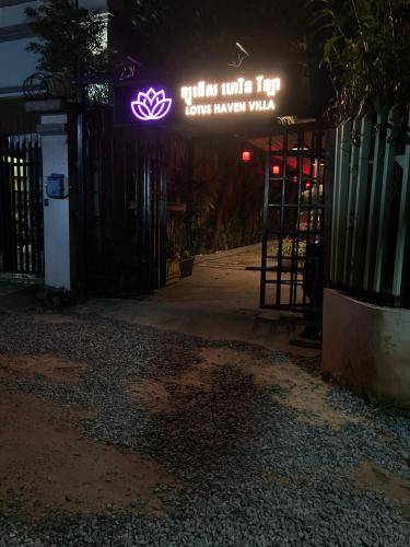 a lit up sign on a gate at night at Lotus Haven Villa in Siem Reap