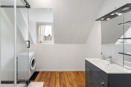 uma casa de banho branca com uma máquina de lavar roupa e um lavatório em L'Escale de la baie ! em Pontorson