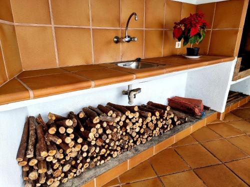 a kitchen counter with a pile of wood next to a sink at Callejones in Mazo