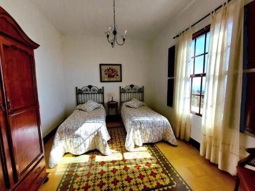 a bedroom with two beds and a window at Callejones in Mazo