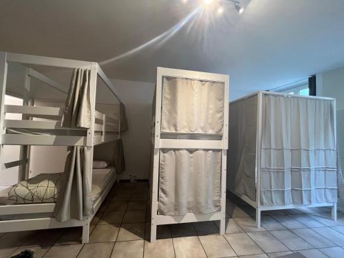 two bunk beds in a room with a ceiling at Auberge de jeunesse hyper centre de Neuchâtel in Neuchâtel