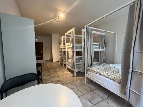 a room with two bunk beds and a table at Auberge de jeunesse hyper centre de Neuchâtel in Neuchâtel