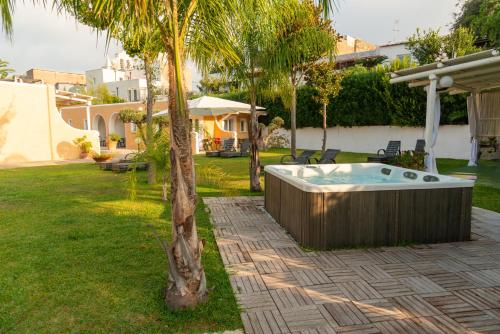 a hot tub in a yard with a palm tree at Hotel Parco Delle Agavi in Ischia