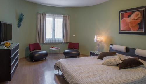 a bedroom with a large bed and two chairs at B&B El Pajarero in Arenas