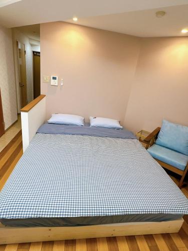 a bedroom with a large bed and a blue chair at 三米-黒門市場-黑门市场-kuromon 202タイプ in Osaka