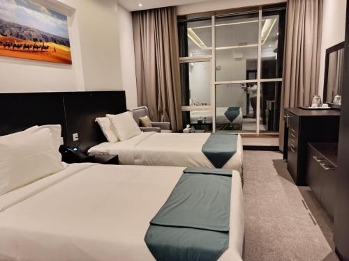 een hotelkamer met 2 bedden en een raam bij Hill Top Muscat in Muscat